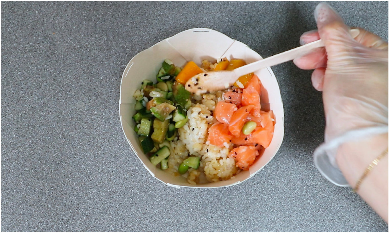 Eating a poke bowl from a Nelumbo container