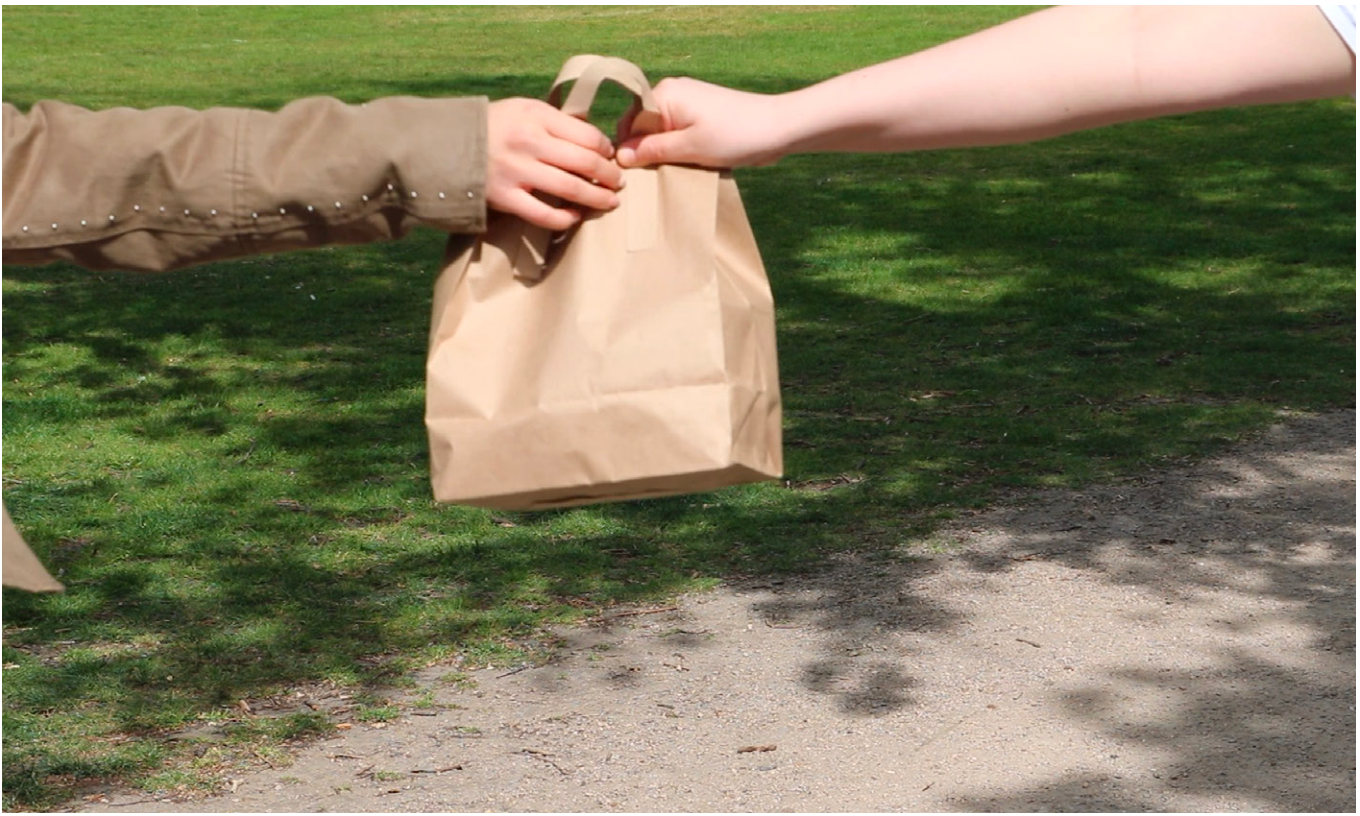 A paper bag handed over in the park