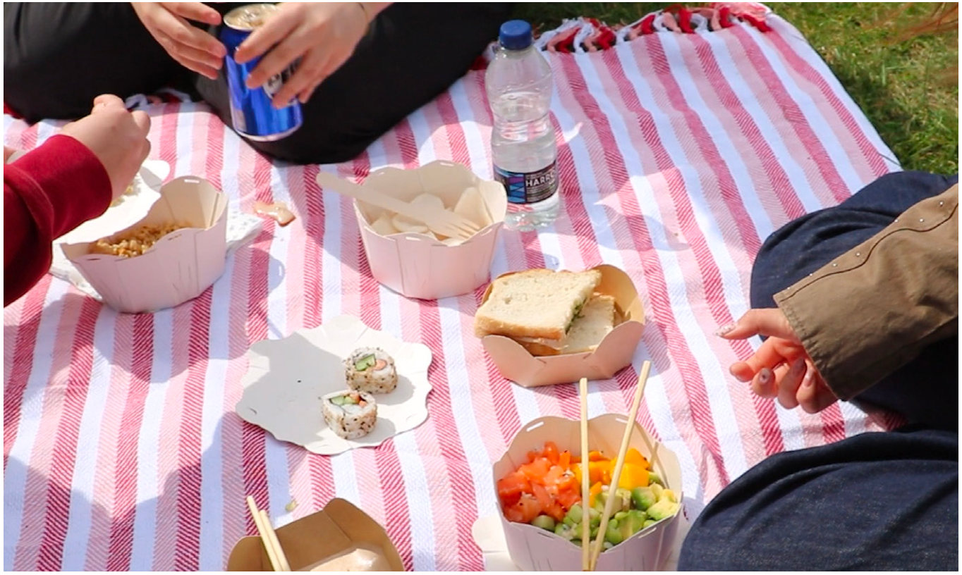 Friends sharing food on a picnic blanket